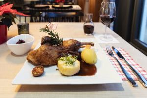 Knusprige Entenkeule mit Kartoffelknödel, Rotkohl und Apfelbeilage.