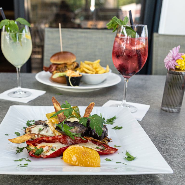 mit Käse überbackenes Grillgemüse und saftiger Burger mit knackigen Pommes