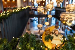 Detailaufnahme einer Weihnachtsdekoration mit Engel an einer beleuchteten Girlande.